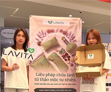 LAVITA — hai người với banner